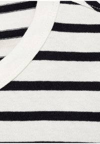 Tessuto di cotone a righe bianche e nere con scollatura a girocollo. La texture è morbida e lavorata a maglia, con righe orizzontali di larghezze variabili.