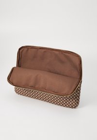 Trousse rectangulaire marron avec motif géométrique crème, ouverte pour montrer l'intérieur en tissu marron uni.