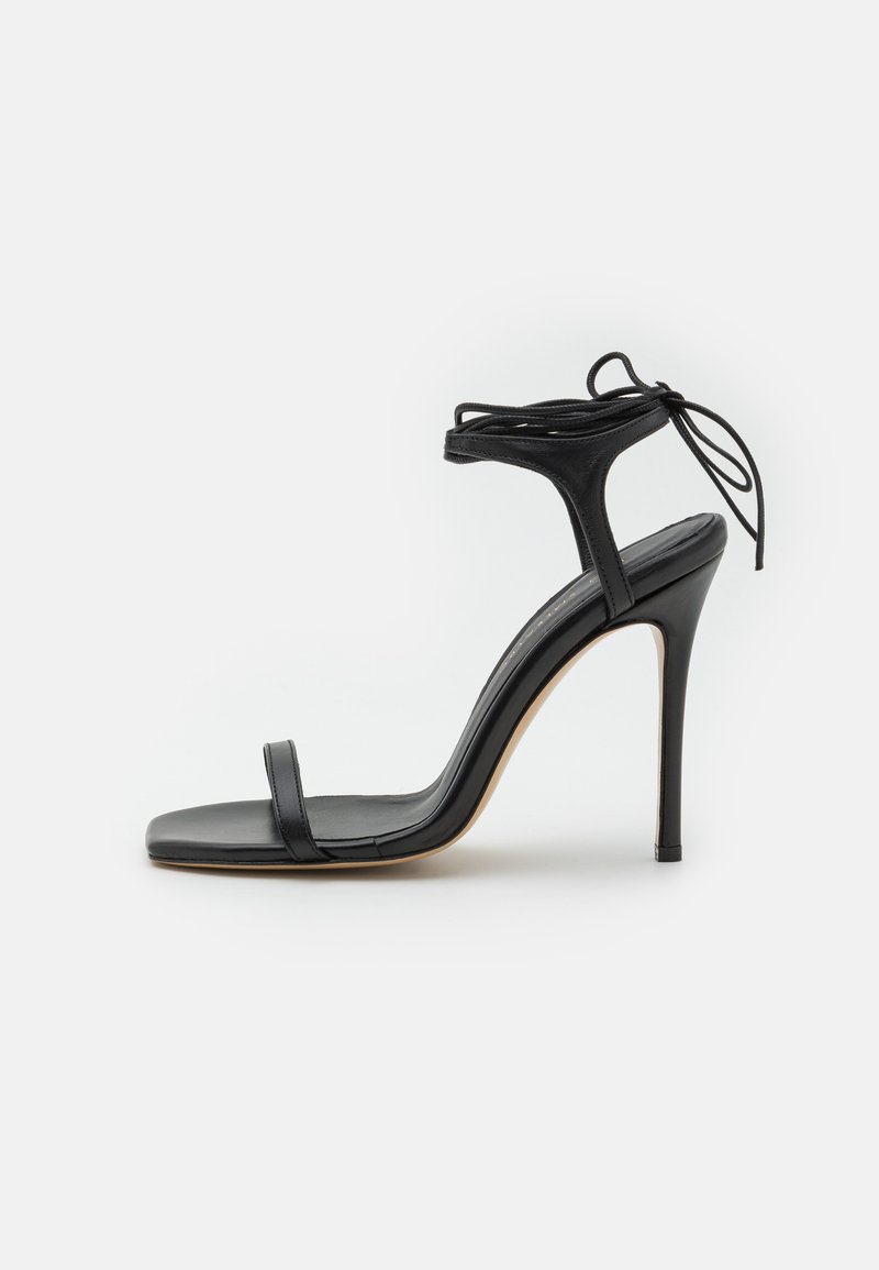 Black leather stiletto sandal with a square toe design, minimal straps, and an adjustable tie at the ankle. Glossy finish and tapered heel.