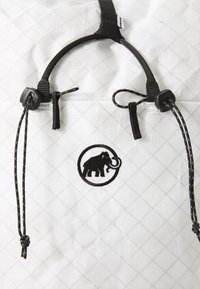 Rucsac alb cu bretele negre, având un logo circular cu un elefant și un model texturat în formă de diamant. Include închideri ajustabile cu șnur.