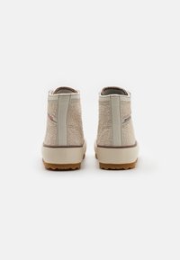Botas de cano alto bege com um upper em tecido texturizado, detalhes sintéticos e uma sola de borracha com um padrão de aderência texturizado.