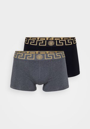 Twee paren mannen boxershorts: de ene grijs en de andere zwart. Beide hebben een gouden patroon aan de tailleband met een medaillonlogo. Zachte stof.