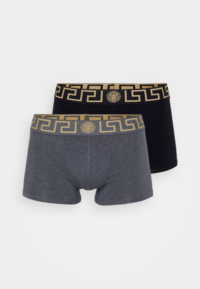 Två par herrboxershorts: en grå och en svart. Båda har en guldmönstrad midjeband med en medaljonglogotyp. Mjuk tyg.