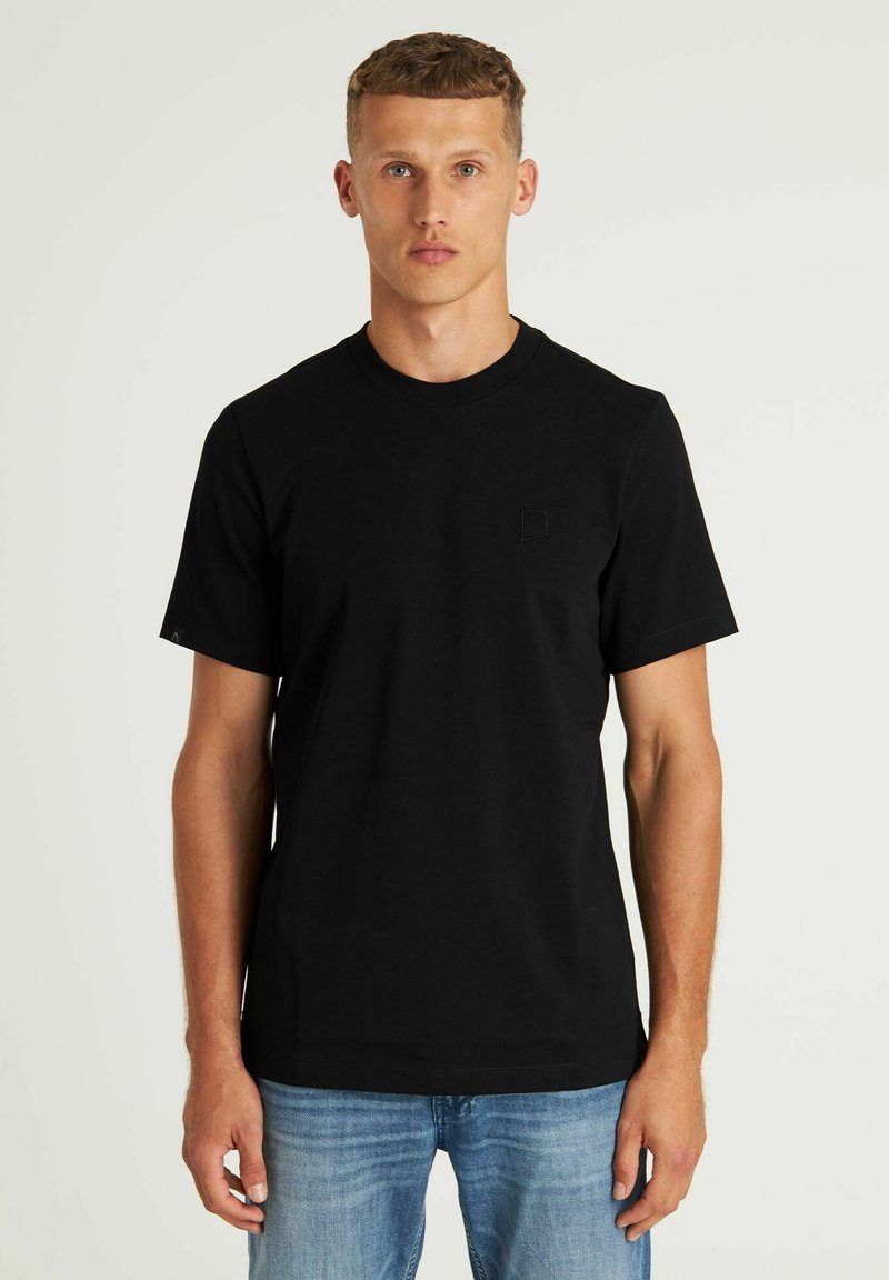 Crna pamukasta majica s kratkim rukavima, kružnim izrezom i malim logotipom na prsima. Glatka tekstura i prilagođeni dizajn.