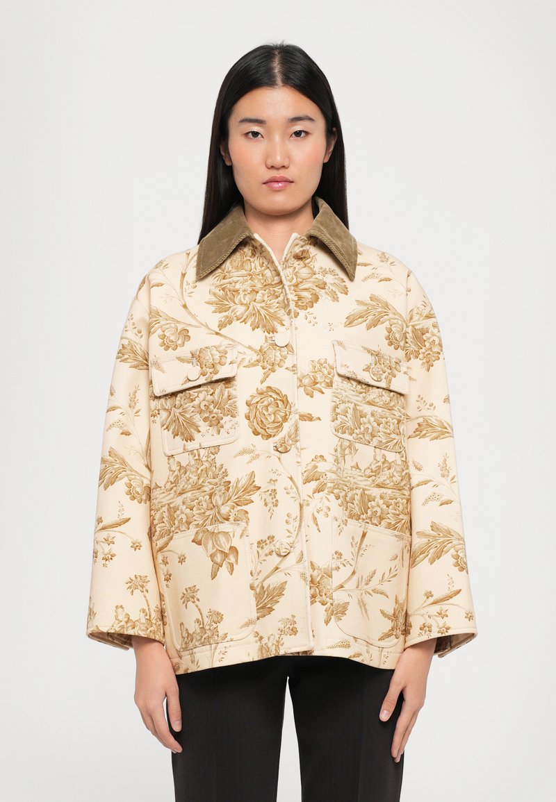 Cremefarbene Jacke mit floralem Muster und braunen Akzenten, ausgestattet mit einem Kragen, zwei vorderen Taschen und einer lockeren Passform. Weicher, strukturierter Stoff.