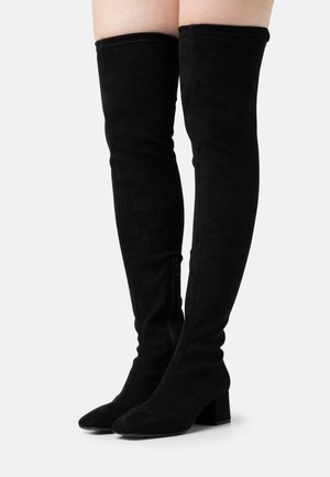 Botas negras de ante por encima de la rodilla, con cremallera en el lado, tacón cuadrado y textura suave sin patrones visibles.