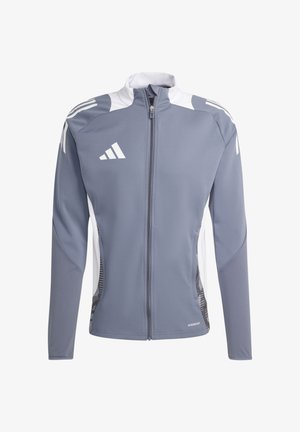 Giacca sportiva grigia con colletto alto, zip completa, dettagli bianchi e pannelli laterali texturizzati. Presenta tre strisce diagonali bianche sulle maniche.