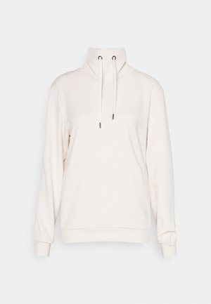 Heledbeez sweatshirt kõrge kaelusega, nööriga kaunistused ja pikad varrukad. Valmistatud pehmest kangast, ribakudumisega mansettide ja alumise servaga.