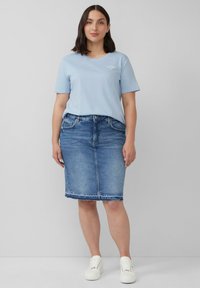 Hellblaues Baumwoll-T-Shirt mit kurzen Ärmeln und rundem Ausschnitt, kombiniert mit einem knielangen Jeansrock in dunkler Waschung und weißen Sneakers.