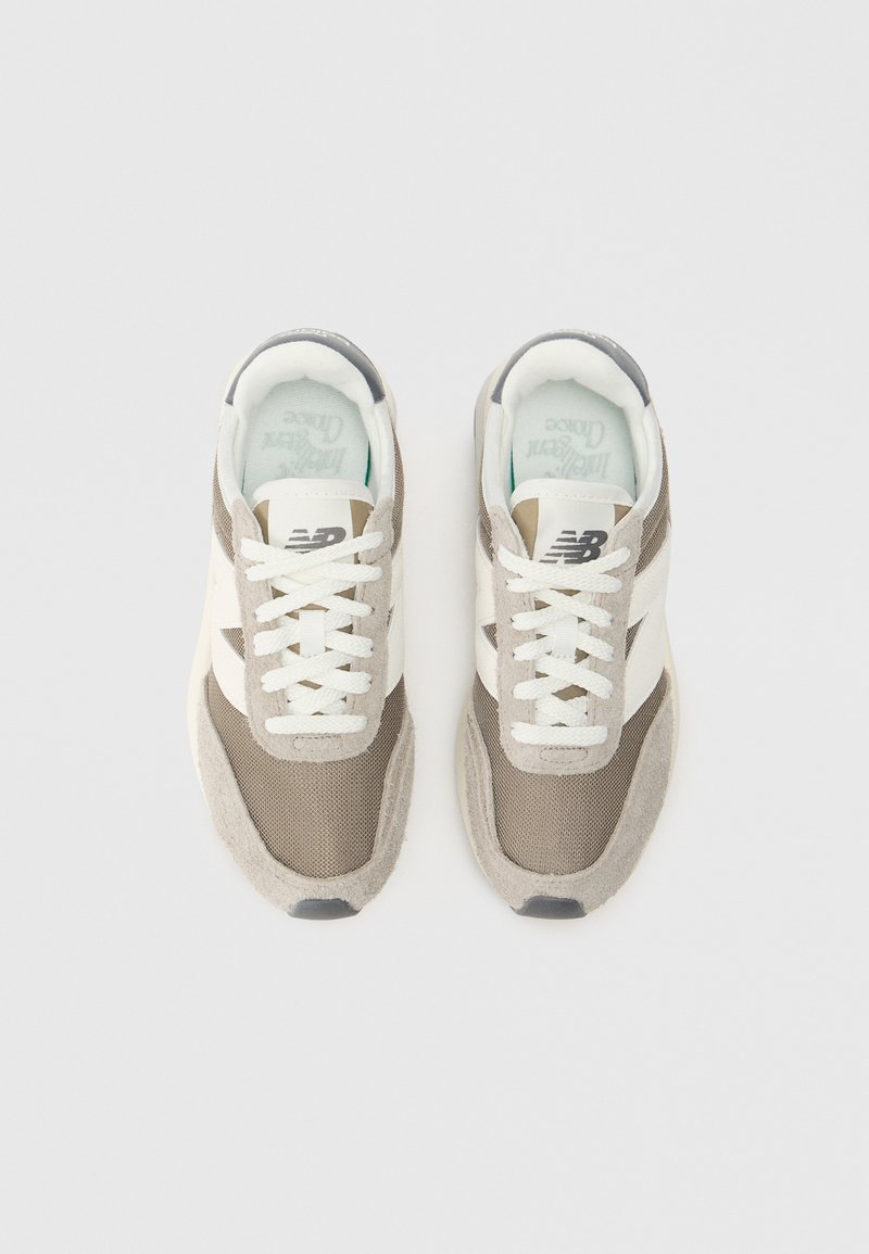 Beige und weiße Sneaker aus Mesh mit Wildlederakzenten. Ausgestattet mit weißen Schnürsenkeln, einem Logo an der Seite und einer strukturierten Sohle. Rundes Zehendesign.