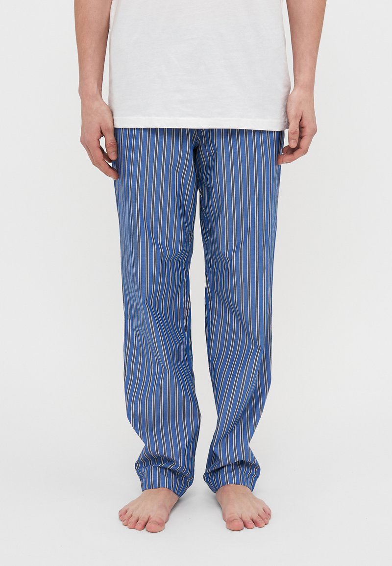 Blauwe gestreepte pyjamabroek met verticale strepen in blauw en multiculturele lijnen. Gemaakt van een lichte stof met een ontspannen pasvorm.