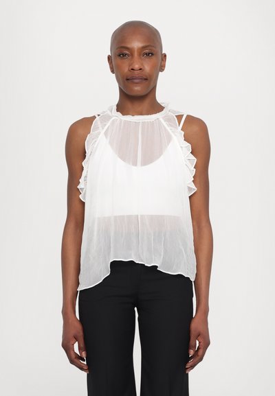 Haut sans manches blanc en tissu transparent, avec un col volanté et des bretelles au dos ; texture douce ; tombe lâchement en dessous de la taille, associé à un pantalon noir.