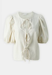 Blusa beige chiara con maniche a sbuffo, caratterizzata da un collo rotondo, chiusura a lacci e tessuto a trama. Design semplice realizzato con materiali naturali.