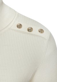 Weißer Ripp-Pullover mit hohem Kragen, der goldene Löwenkopf-Buttons an der Schulter und einen weichen, strukturierten Stoff aufweist.