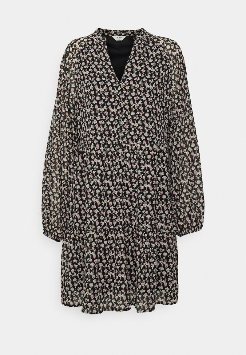 Robe noire à manches longues avec imprimé floral blanc et rose, encolure en V et jupe à volants froncés.