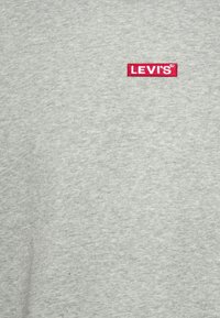 T-shirt in cotone grigio con logo rettangolare rosso di Levi's sul petto, con una texture liscia e scollo rotondo classico.