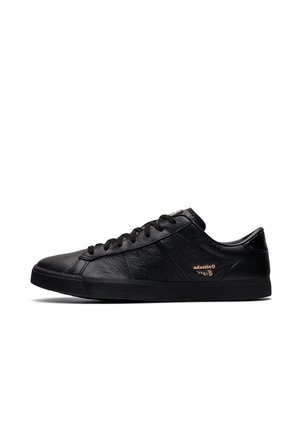Low-profile black leather sneaker with black laces, rubber sole, and small gold lettering on the side near the heel.