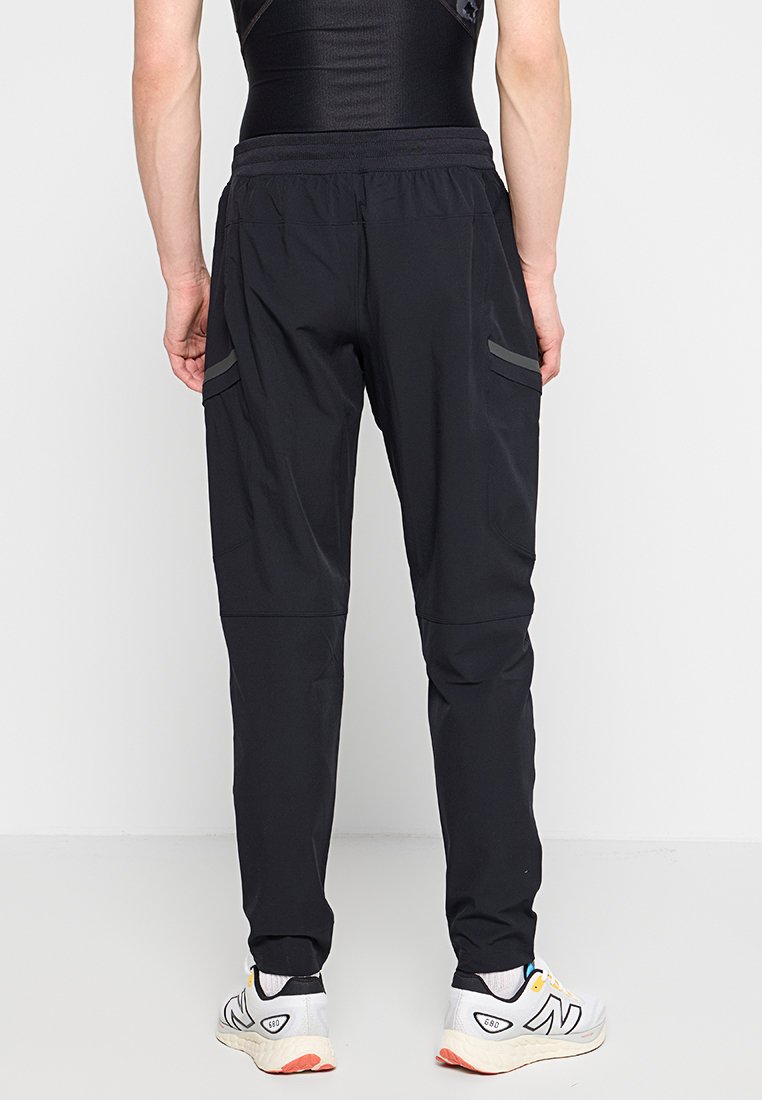 Pantalones deportivos negros con un diseño ajustado, cinturilla elástica, dos bolsillos laterales y acentos reflectantes en los muslos.