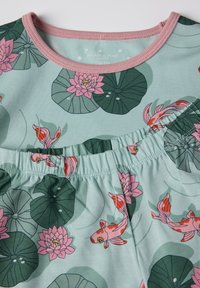 Lichtgroene stof met roze waterlelies en oranje koi-vissenpatronen, met een roze geribbelde halslijn en een gathered taille-gedetailleerde afwerking.