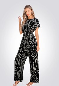 Une combinaison noire présentant des motifs ondulés blancs, des manches courtes, une ceinture à la taille, et des pantalons à jambes larges. Texture de tissu lisse.