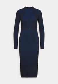Stickad klänning i mörkblått med vertikal ribbad textur, långa ärmar, hög hals och geometriska detaljer som skapar en figurnära silhuett.