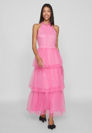 Pink tulle dress with a halter neck, featuring layered, ruffled tiers and a fitted waist. Black bow-accented shoes complete the look.