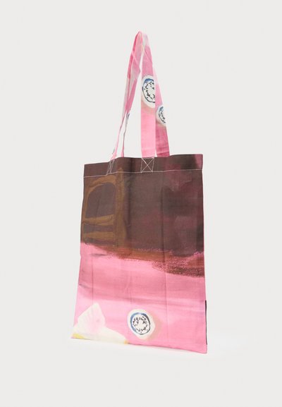 Τσάντα tote με μακριές ροζ λαβές και αφηρημένο σχέδιο σε ροζ, καφέ, λευκό και μπλε, κρεμασμένη και εμφανιζόμενη σε λευκό φόντο.