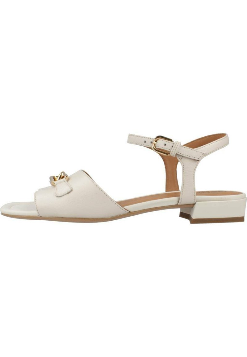 Sandal in pelle beige con punta aperta, cinturino alla caviglia regolabile, tacco a blocco piccolo e accentuazione decorativa a fiocco sulla parte superiore.