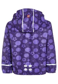 Lila regnjacka med mönster av cirklar, blommor och LEGO-ansikten. Har en huva, reflexränder och elastiska manschetter för en åtsittande passform.