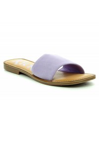 Lilla suedetrek sandal med bredt krydsbåndsdesign, beige indersål, flad sål og hvide syninger. Ingen hæl.