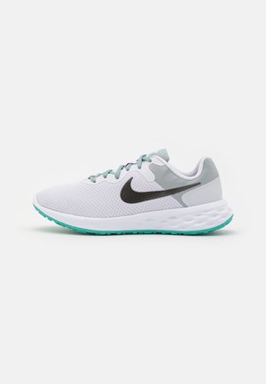 Chaussure de course Nike blanche et gris clair avec des lacets turquoise, semelle turquoise assortie et logo Swoosh Nike noir sur le côté.