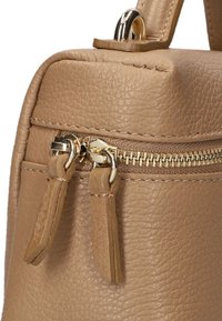 Helle Lederhandtasche mit strukturiertem Oberflächen, ausgestattet mit einem goldenen Reißverschluss und Zuglaschen. Kompakte rechteckige Form mit sichtbaren Steppnähten.