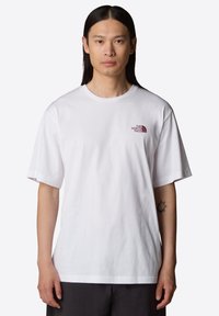 Camiseta blanca de manga corta hecha de algodón, con un logo rojo en el lado izquierdo del pecho, con un cuello redondo y un corte relajado.
