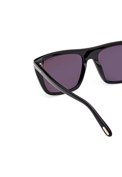 Ochelari de soare negri cu ramă tip cat-eye, lentile nuanțate de violet și finisaj neted și lucios. Prezintă un accent subțire, metalic aurie pe brațele ochelarilor.
