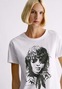 Witte katoenen t-shirt met een zwart grafisch ontwerp van een persoon met een zonnebril en de tekst "Born in London" en "Pepe Jeans."