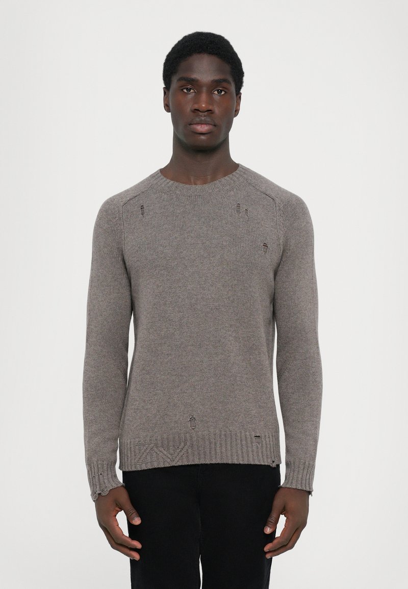 Pull en tricot gris avec un col rond, un ourlet côtelé et des détails usés subtils. Confectionné en tissu souple et texturé.