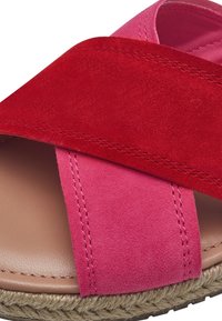 Sandali in pelle scamosciata con cinghie incrociate rosse e rosa, una soletta neutra e una suola in juta intrecciata per un tocco di texture e aderenza.