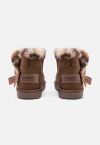 Bottines en daim marron avec un col en fausse fourrure, un dos texturé et un nœud décoratif sur le côté. Marque affichée sur le talon.