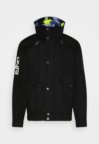 Veste noire à capuche avec boutons à l'avant, poches poitrine zippées, poches à rabat, ourlet élastique et doublure de capuche colorée à motifs.