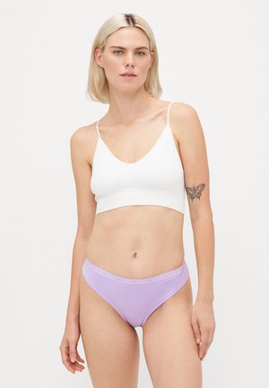Bralette en coton blanc avec des bretelles fines, associé à des slips légers de couleur lilas avec une ceinture texturée. Tissu lisse et extensible.