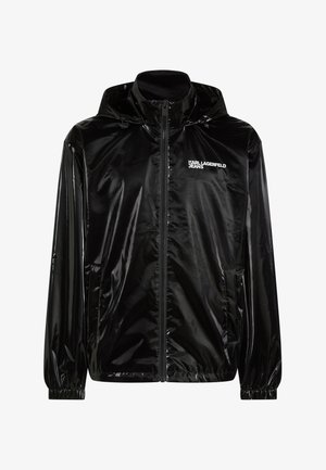 Giacca nera lucida con cappuccio, cerniera frontale, polsini elastici, tasche laterali e logo "KARL LAGERFELD JEANS" sul petto.