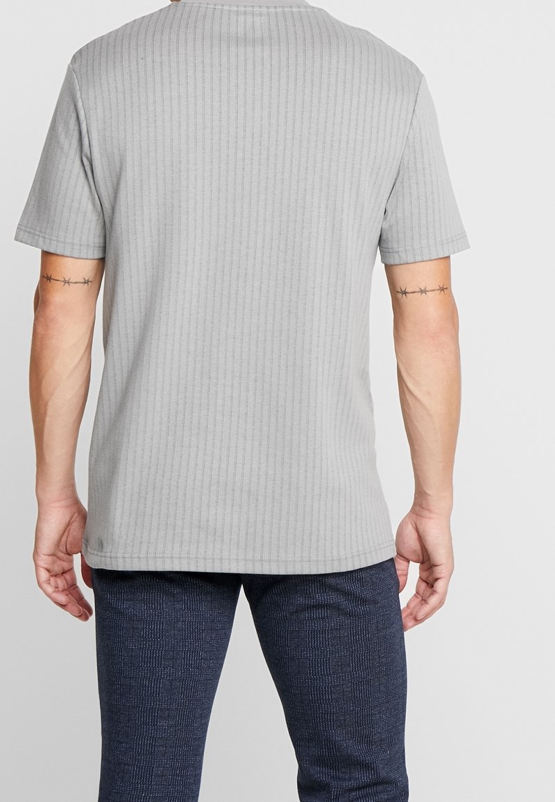 Grå ribbad t-shirt med kort ärm och rund hals, med en mjuk textur och rak nederkant, sedd bakifrån.