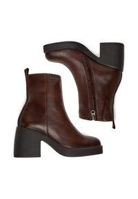 Botas de tobillo de cuero marrón oscuro con tacones de bloque, cremalleras laterales y detalle metálico de marca en el tobillo exterior.