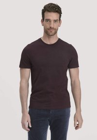 Bordo T-shirt met korte mouwen en een ronde hals, van gladde katoen, met een fitted snit en subtiele stikdetails. G gedragen met gestructureerde marineblauwe broek.