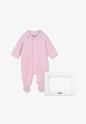 Grenouillère rose pour bébé avec pieds, manches longues, col et lignes diagonales blanches, à côté d'une boîte rectangulaire blanche de la marque BOSS.