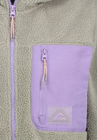 Fleecejack met een gestructureerd grijs lichaam, een paarse borstzak met rits en een driehoekige logopatch met de tekst "OUTDOOR".