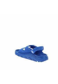 Sandalias azules con parte superior texturada y diseños recortados, correa ajustable y una suela gruesa y contorneada para mayor comodidad y soporte.
