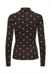 Langærmet top i mørkebrun ribbet stof med store hvide polkaprikker. Høj halsudskæring med flæset kant og tætsiddende pasform.