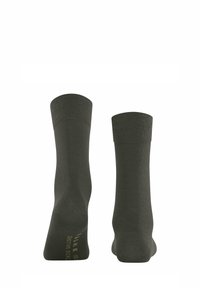 Olivgrüne Kniesocken mit einer glatten Strickstruktur, geripptem Bund und dezentem Branding in Gold auf der Sohle. Sie haben eine anliegende Form.