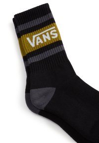 Sorte crew-sokker med en ribbet kant, stribede grå og sennepsfarvede accenter, med en hvid "VANS" logo fortil.